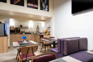 图卢兹阿尔比昂酒店的一间带桌椅的客厅和一间厨房