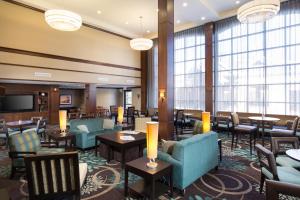 莫米Staybridge Suites Toledo/Maumee, an IHG Hotel的酒店大堂设有桌椅和窗户。