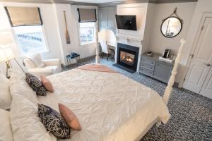 米斯蒂克捕鲸船酒店的一间卧室设有一张大床和一个壁炉