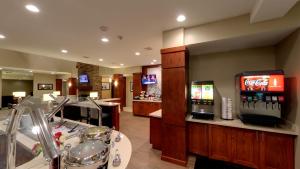 安娜堡Staybridge Suites Ann Arbor - Research Parkway, an IHG Hotel的一间带酒吧的餐厅,配有苏打水机