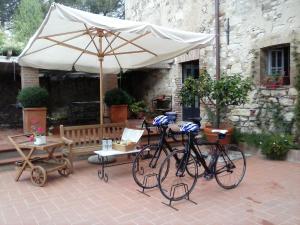卡斯德尔诺沃贝拉登卡圣奎里科农家乐酒店的两辆自行车停在一个露台的伞下