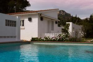 蒙特罗伊Ca l'Eli different experience的一座白色的房子,前面设有一个游泳池