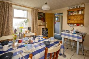 PenpillickVine Cottage的一间配备有蓝白色桌椅的用餐室