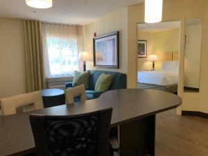 罗利罗利克拉布特里烛木套房酒店的酒店客房设有一间卧室、一张桌子和一张床
