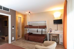 伊莫拉唐纳特洛伊莫纳酒店的配有双层床和书桌的酒店客房
