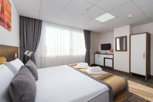 安塔利亚Grand Gulluk Hotel & Spa的酒店客房设有一张大床和一台电视机。