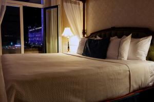 墨西哥城墨西哥格兰城市酒店的一间卧室设有一张大床和窗户