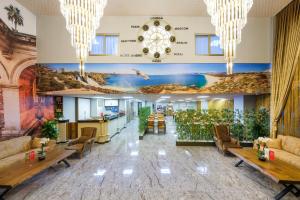安塔利亚Grand Gulluk Hotel & Spa的大堂配有沙发、桌子和壁画
