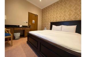 斯劳SK Baylis House Hotel的一间卧室配有一张大床、一张桌子和一张四柱床。