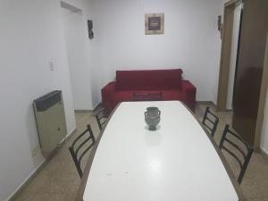 科尔多瓦Departamento a estrenar excelente ubicacion, 1 cuadra de la terminal的一间设有白色桌子和红色沙发的房间