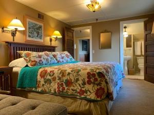 伊斯特海湾Kangaroo House Bed & Breakfast的一间卧室配有一张带鲜花毯子的床和一间浴室