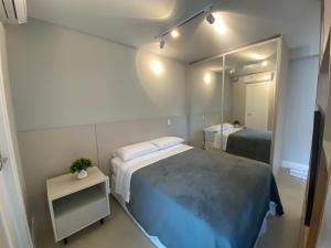 圣保罗SUA CASA NA VILA MADALENA的一间卧室配有一张大床和镜子