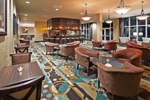 博福特博福特21号公路假日套房酒店的大堂设有桌椅和酒吧。