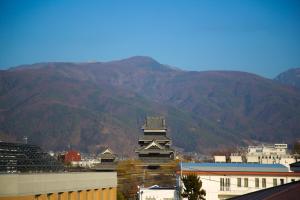 松本The Celecton Matsumoto的一座高大的山丘建筑