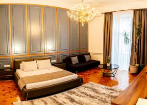 克卢日-纳波卡马太考尔温公寓的一间卧室配有一张床、一张沙发和一个吊灯。