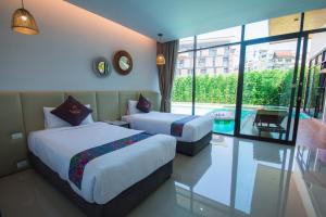普吉镇Good Night Pool Villa Phuket - SHA Plus的酒店客房带两张床和一个游泳池
