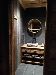 欧特吕斯Chambres et Tables d'Hôtes Le Choton à Nono - Col du Joly Beaufortain的一间带镜子和木制梳妆台的浴室