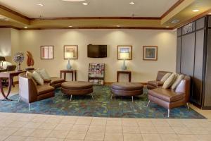 特克萨卡纳-德克萨斯特克萨卡纳烛木套房酒店的一间配备有家具及平面电视的等候室