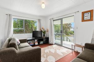 芒阿法埃The Taranui Cottage - Mangawhai Heads Holiday Home的带沙发和电视的客厅