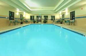 费耶特维尔菲耶特维尔驻桥套房酒店的大楼内一个带桌椅的游泳池