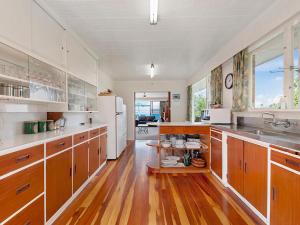 陶波Lofty Lakeviews - Acacia Bay Holiday Home的一间铺有木地板并配有白色家电的大厨房