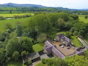 GlasburyGlanhenwye Courtyard Cottages的田野中旧房子的空中景观