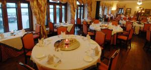GajnerGajner Palace-Heritage by HRH Group of Hotels的一间设有白色桌椅和窗户的用餐室