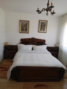 瓦马Casa Gotika的一间卧室配有一张带白色床单和吊灯的床。