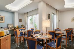 雅典阿托斯酒店的用餐室配有木桌和椅子