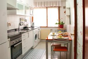 奥维多Apartamento Araceli próximo a clínica Oftalmológica Fdez Vega的厨房配有水槽和带洗碗机的桌子。
