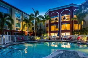 布雷登顿西阿玛里洛智选假日酒店及套房的棕榈树建筑前的游泳池