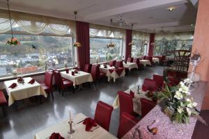 巴特拉斯费拉恩布里克酒店的餐厅设有桌子和红色椅子以及窗户。