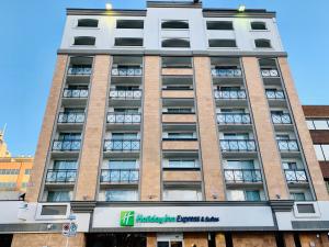 卡尔加里Holiday Inn Express and Suites Calgary, an IHG Hotel的前面有标志的高楼