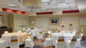摩根城摩根城小虎岛智选假日酒店的宴会厅配有白色的桌子和白色的椅子