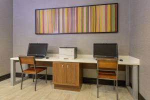 北湾北部湾智选假日酒店的一张带两个显示器的桌子、一台打印机和两把椅子
