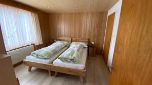 翁根艾彻里格小屋酒店的一间卧室配有一张带两个枕头的木床