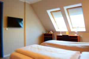 Schwentinental克劳斯多尔福霍夫酒店的一间卧室配有两张床、一张桌子和一台电视。