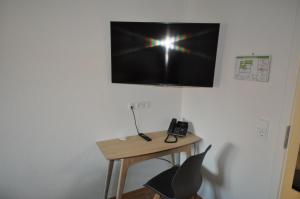 MichelfeldD´r Rechenmacher的一张桌子、一部电话和一台墙上的电视