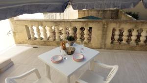 il-BaħrijaMamina's House的带阳台的客房内的白色桌椅