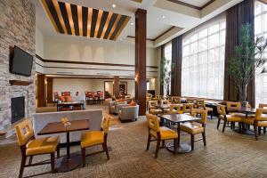 North WalesStaybridge Suites Montgomeryville, an IHG Hotel的一间带桌椅和壁炉的餐厅