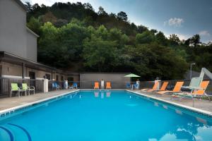 Middlesboro米德尔斯堡智选假日酒店的一个带躺椅的游泳池和一个山