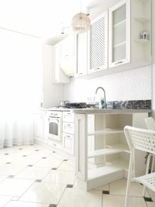 苏梅Manufactura apartments 2的白色的厨房配有白色橱柜和水槽