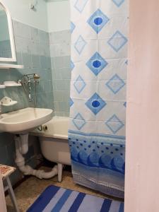 切尔尼戈夫Уютная квартира посуточно улица Белова的浴室配有水槽、浴缸和淋浴帘