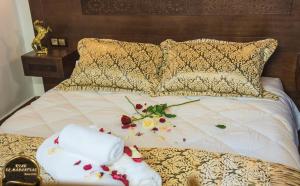 得土安Riad EL Manantial,Patrimonio del S XIX的一张带两条毛巾和鲜花的床