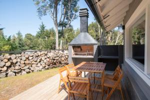 拉安戈斯图拉镇BOG Bosque de Manzano的木甲板配有桌椅和烧烤架