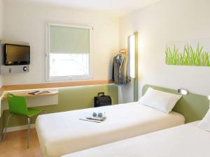塔布达尔布宜必思快捷酒店的客房设有两张床、一张桌子和一台电视机。