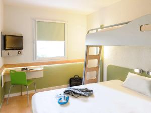 龙尚Ibis budget Lille Ronchin - Stade Pierre Mauroy的一间卧室配有一张床和一张双层床。