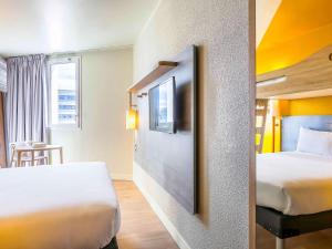 雅芳阿翁枫丹白露宜必思快捷酒店的一间酒店客房,设有两张床和电视
