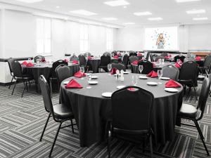 渥太华Novotel Ottawa City Centre Hotel的一间会议室,配有桌椅和红色餐巾