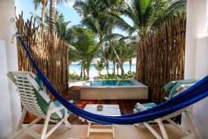 图卢姆Cabanas Tulum- Beach Hotel & Spa的游泳池间内的吊床和椅子